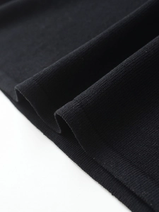Detailed macro view of high-quality black knit fabric showing texture and soft drape