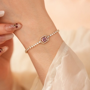 Close-up of pink rectangular zircon bracelet with shimmering pave stones on woman's wrist