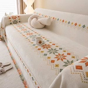 Detail of bohemian geometric star pattern on a beige flannel cushion with elegant tassels