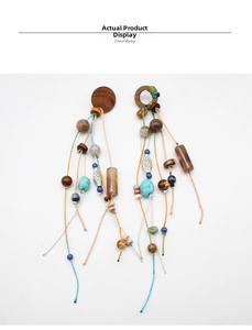 Detailed shot of ethnic boho tassel earrings with wooden beads and turquoise accents