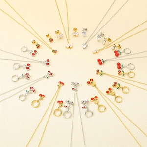 Ensemble de bijoux en acier inoxydable avec motifs cerises dorés et argentés sur beige
