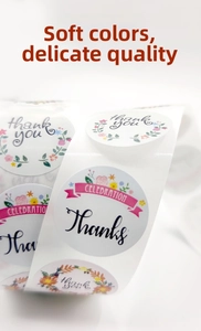 Detailed view of floral thank you stickers and celebration labels on a decorative roll