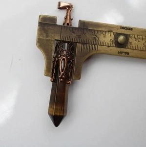 Detailopname van breedtemeting van een zeshoekige tijgeroog kristallen hanger