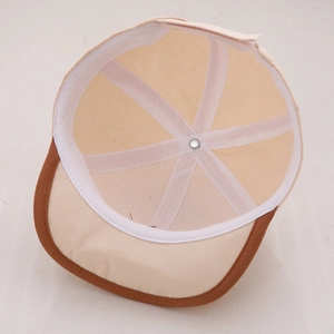 Détail de l'intérieur d'une casquette bébé avec coutures à six panneaux et bouton métal