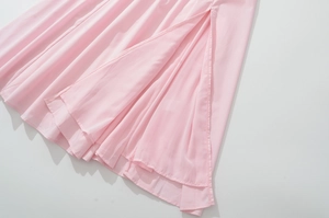 Close-up of pink french style dress featuring a high side slit and soft pleated fabric