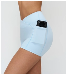 Detail of high-waist light blue yoga shorts with V-cross waist and functional side phone pocket