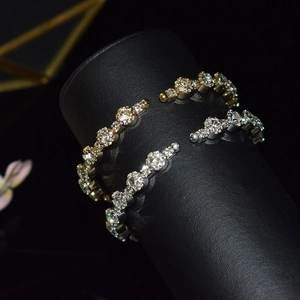 Close-up of gold and silver crystal bangles on a black stand with sparkling rhinestones