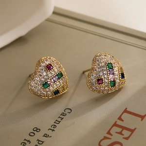 Orecchini a cuore vintage con zirconi colorati e cristalli su un libro
