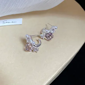 Detailed close-up of silver earrings with light purple square crystal and tiny pearl