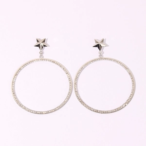 Detailed view of silver hoop earrings with star studs and shimmering rhinestones