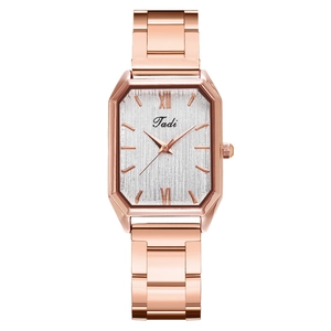 Macro detail of rose gold octagonal case with brushed silver dial on a metal watch