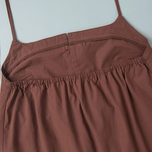 Detail of brown strap top featuring elastic smocked back and neat overlock stitching