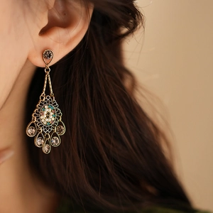 Close-up of vintage gold hollow diamond earrings with tassels on model's ear