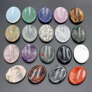 Polished natural crystal gua sha thumb stones in various colors on dark background