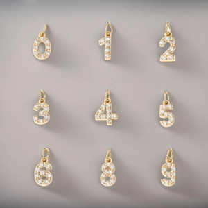 Collection of gold number pendants from 0 to 9 featuring micro-pave cubic zirconia crystals