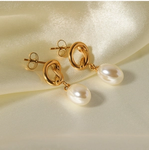 Detailed close-up of French vintage Baroque pearl earrings with a golden knot design