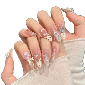 Sweet pink press-on nails with white dots, plaid patterns and 3D bow pearl accents