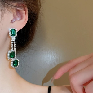 Nahaufnahme der Vintage Smaragd Quastenohrringe mit grünen Steinen und Diamanten