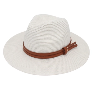 Detail of white woven Panama hat featuring a brown faux leather band and tassel accents