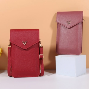Detail of red and pink mini crossbody phone bags with deer head metal buckles