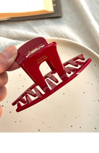 Detail of a large dark red rectangle hair claw clip with golden France Handmade text