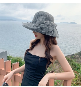 Detail of grey sun hat with ruffled organza flower on the side for elegant beach wear