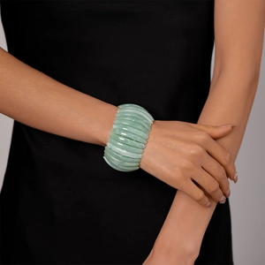 Détail d'un bracelet en résine acrylique vert clair avec texture marbrée sur le poignet