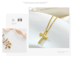 Detail view of a gold cross pendant with cubic zirconia inlay on a delicate O-chain