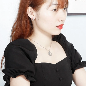 Gros plan d'un mannequin portant un collier lune et étoile en argent avec boucles d'oreilles