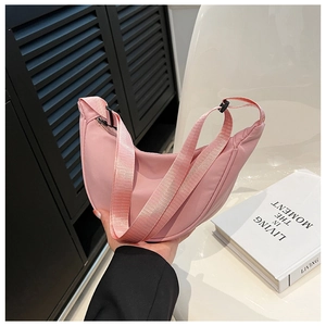 Detailed view of pink nylon crescent hobo bag with adjustable wide strap and zipper