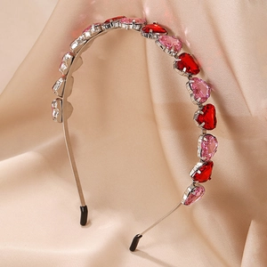 Fashionable heart-shaped crystal headband with red and pink gemstones on silver band