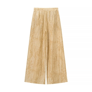 Detailed flat lay of light gold wide-leg trousers with floral jacquard texture on white