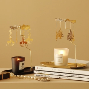 Rotating gold candle holder with reindeer and tree charms on a tray for home decor