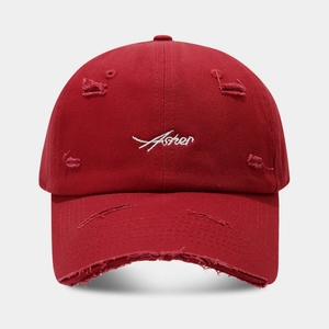 Detailed embroidery of white Asher text on distressed vintage dark red cotton baseball cap