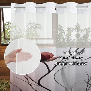 Detail of sheer white shower curtain with floral print showing light filtering fabric