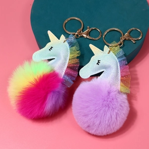 Detalle de llaveros de unicornio de peluche brillante con encaje y cierre de dorado