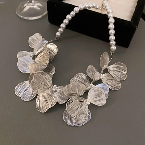 Detail of silver hollow metal flower petals joined with elegant white faux pearl chain