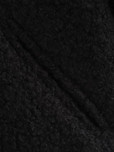 Close-up of the curly black faux fur texture and plush fabric of the bomber jacket