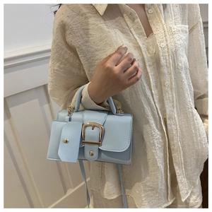 Close-up of light blue mini square bag with gold buckle and detachable coin purse