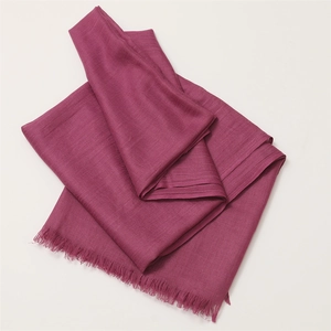 Detail shot of folded purple cotton linen scarf with soft fringe edges and fine texture