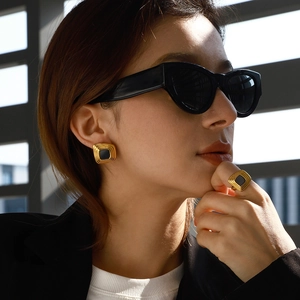 Elegant gold titanium steel jewelry set featuring square black enamel earrings and ring