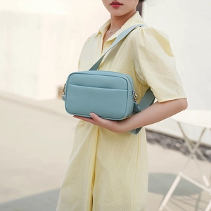 Close-up of light blue PU leather crossbody bag with lychee texture and adjustable strap