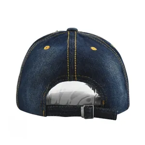 Detail of dark blue denim baseball hat showing yellow stitching and metal buckle strap