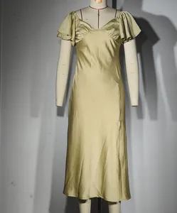 Détail de la robe longue en satin doré champagne avec col en V et fente haute latérale