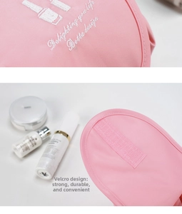Close-up of pink drawstring makeup bag showing embroidery and velcro closure detail