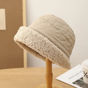 Bonnet matelassé beige avec bord en laine d'agneau chaude sur support en bois