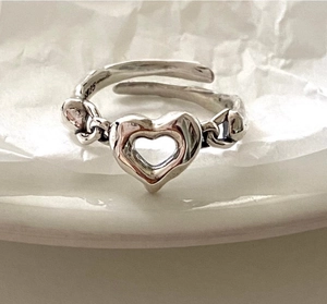Macro shot of S925 sterling silver adjustable ring with hollow heart and Cuban chain band