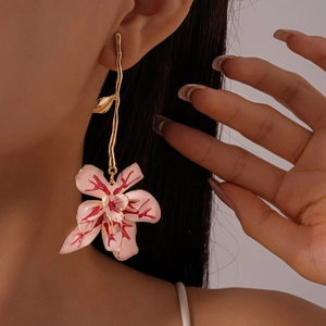 Detailed view of pink orchid drop earrings with gold metallic texture and enamel finish