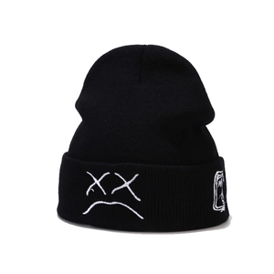 Black ribbed knit beanie with white embroidered expression for outdoor warmth and style