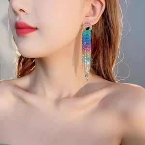 Macro shot of long rainbow tassel earrings with sparkling colorful rhinestones